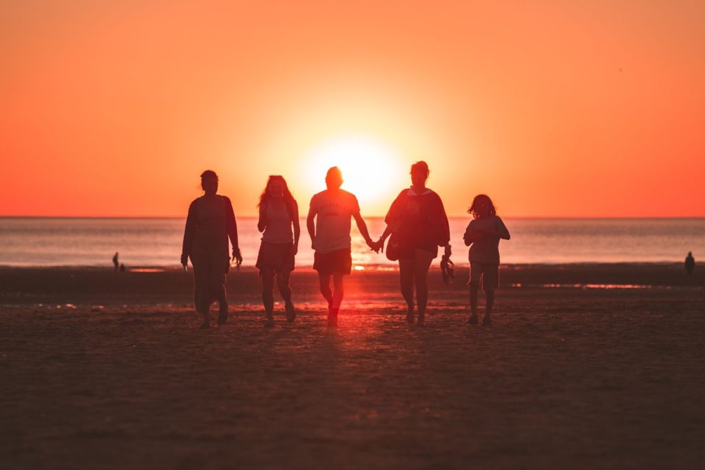 A family holding hands at sunset.